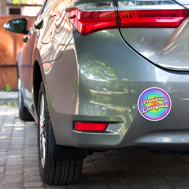 Car with a 'Modern Lorefolk' sticker on the rear, parked outdoors.
